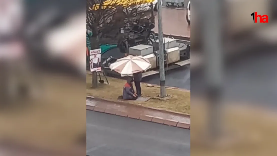 Kaldırımda yağmur altında namaz kılan iş arkadaşına şemsiye tuttu
