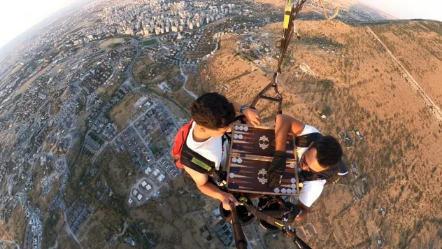 Yer çekimine meydan okuyan yamaç paraşütçüleri havada tavla oynadı