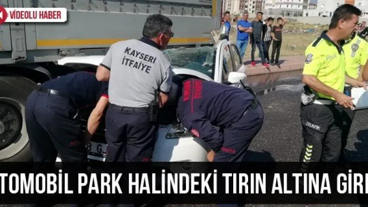 Otomobil park halindeki tırın altına girdi